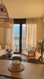 ein Wohnzimmer mit einem Tisch und ein Zimmer mit Aussicht in der Unterkunft Homa Luxury Apartments Tivat with seaview in Donja Lastva