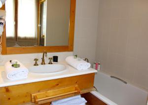 a bathroom with a sink and a tub and a mirror at Appartement Solaise Plein Sud By Valdiski in Val dʼIsère