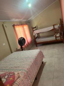 - une chambre avec 2 lits, un ventilateur et une fenêtre dans l'établissement Chácara Sonho Realizado, à São Pedro