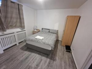 um pequeno quarto com uma cama e uma janela em Luxury House, 4 bedrooms fully furnished em North Woolwich