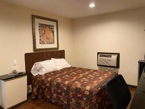 A bed or beds in a room at Budget Inn