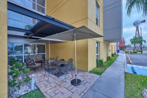 a patio with a table and an umbrella next to a building at City Express by Marriott Monterrey Norte in Monterrey