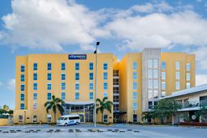 un bâtiment jaune avec une camionnette garée dans un parking dans l'établissement City Express by Marriott Paraiso, à Paraíso