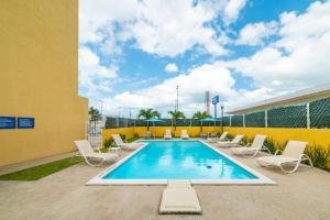 uma piscina com espreguiçadeiras e uma piscina em City Express by Marriott Paraiso em Paraíso