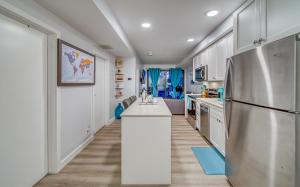 uma cozinha com armários brancos e um frigorífico em Steps from downtown Calgary a Suite with a VIEW em Calgary
