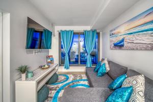 uma sala de estar com um sofá cinzento e almofadas azuis em Steps from downtown Calgary a Suite with a VIEW em Calgary