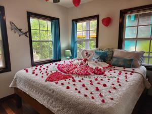 una cama con un montón de corazones en ella en Bella Vista Resort Belize en San Pedro