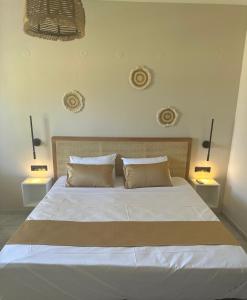 a bedroom with a large white bed with two lamps at Electra Studios in Palaiochora