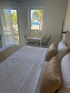 1 cama blanca grande en una habitación con ventanas en Electra Studios, en Palaiochóra