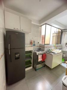 cocina con nevera negra y fogones en Apartamento privado pueblo libre, en Lima