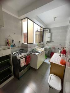 una pequeña cocina con fogones y fregadero en Apartamento privado pueblo libre, en Lima