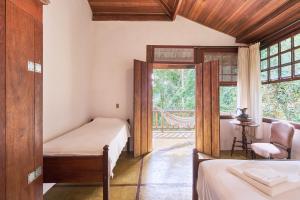 um quarto com 2 camas e uma janela em Casa Amaargi Picinguaba em Picinguaba