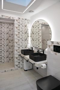 een badkamer met 2 wastafels en een spiegel bij Triton Capri in Capri