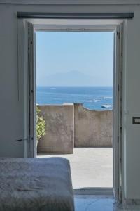 een deur naar een slaapkamer met uitzicht op de oceaan bij Triton Capri in Capri