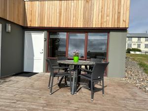 a patio with a table and chairs on a deck at Guesthouse Dyngja in Höfn