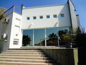 a white house with glass windows and stairs at Casa en bonito barrio residencial - Ciudad in El Challao