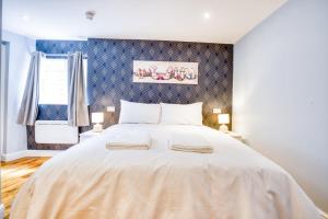 a large white bed in a room with a window at Suite 2- 2 Bed Apartment in Lincoln