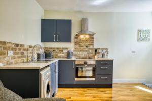 a kitchen with black appliances and a brick wall at Suite 2- 2 Bed Apartment in Lincoln