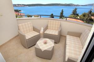 Un balcón con sillas y una mesa con vistas al océano. en Cvita apartments, en Trogir
