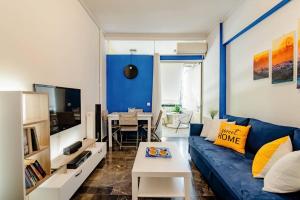 uma sala de estar com um sofá azul e uma mesa em Athens Paradise Apartament 50 sqm Near To Metro #2 em Atenas