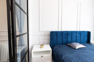 グダニスクにあるGlam & Loft Apartmentsのベッドルーム(青いベッド1台、サイドテーブル付)