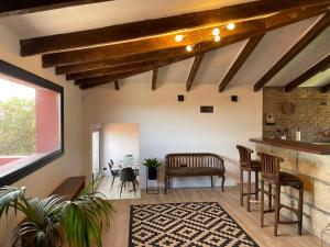 a living room with wooden ceilings and a table and chairs at Casa Rural La CaTaTa in Las Lagunas
