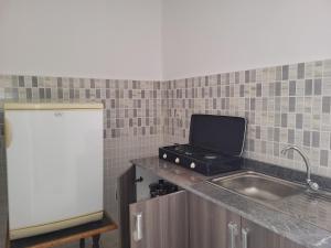 a kitchen with a sink and a laptop on a counter at Complexe tamuda doha tetouan in Tetouan