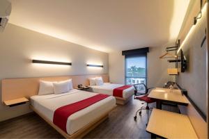 Habitación de hotel con 2 camas y escritorio en City Express Plus by Marriott Guadalajara Palomar, en Guadalajara