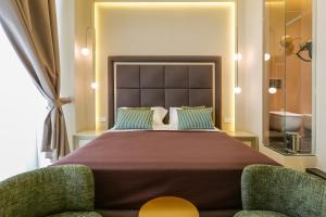 a bedroom with a large bed and two chairs at Maison San Carlo Luxury Suites in Naples