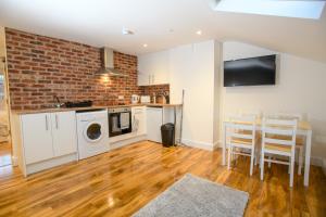 a kitchen with a washer and dryer and a brick wall at Cathedral View apartments in Lincoln