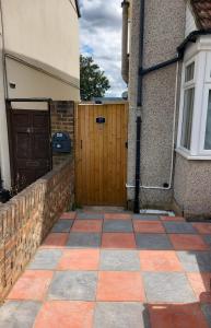 a driveway of a house with a wooden door at Heronsgate GH013 in Erith