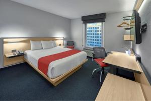 提华纳提华纳里约城市快捷酒店的一间配有床、书桌和电脑的酒店房间