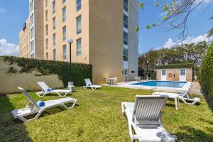 a yard with lounge chairs and a swimming pool at City Express by Marriott Chetumal in Chetumal