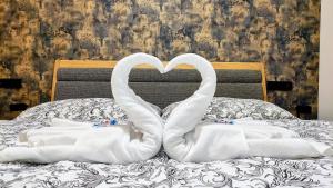zwei Schwäne, die auf einem Bett eine Herzform machen in der Unterkunft GRAND SPA Harrachov - Wellness Luxury Apartments in the center of Harrachov with a private whirlpool, kitchen, sauna and terrace in Harrachov