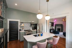 eine Küche mit einem Waschbecken und einer Theke mit rosa Stühlen in der Unterkunft Prime Walkable Location Spacious Home w Hot Tub in Nashville