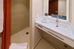 uma casa de banho com um lavatório e um chuveiro em City Express Junior by Marriott Tijuana Otay em Tijuana