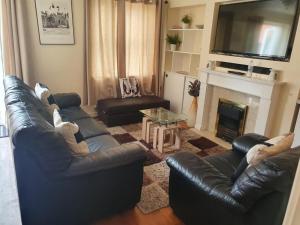 a living room with two leather couches and a fireplace at Heronsgate GH007 in Woolwich