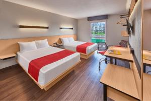 um quarto de hotel com duas camas e uma secretária em City Express by Marriott Celaya Galerias em Celaya