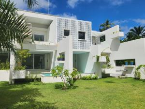 une maison blanche avec une pelouse devant elle dans l'établissement Auka Boipeba, à Île de Boipeba