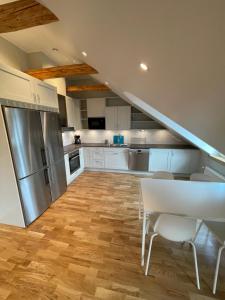 uma cozinha com armários brancos, uma mesa e um frigorífico em Home Inn HVG54 em Estocolmo