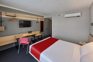a hotel room with a large bed and a desk at City Express by Marriott Durango in Durango