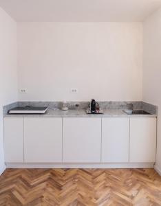 a kitchen with white cabinets and a counter top at Althea in Viareggio