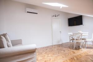 a living room with a table and a tv on the wall at Althea in Viareggio