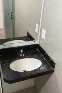 a bathroom counter with a sink and a mirror at Hotel Central in Boa Esperança