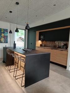 a kitchen with a black island with bar stools at Villa Pajunkissa in Rovaniemi