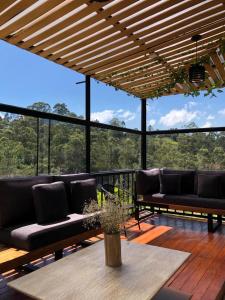 un patio con sofás y una mesa en una terraza en La parsela, en Rionegro