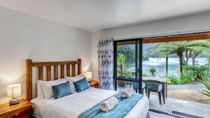 a bedroom with a bed and a view of the ocean at Lochmara Lodge in Lochmara Bay