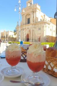 dois cocktails sentados numa mesa em frente a um edifício em B&B del centro storico *** em Rosolini