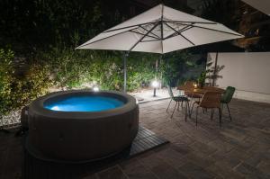 einen Whirlpool mit einem Tisch und einem Sonnenschirm in der Unterkunft VELVET HOME PESCARA - Luxury Apartment in Pescara