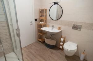 een badkamer met een wastafel, een toilet en een spiegel bij VELVET HOME PESCARA - Luxury Apartment in Pescara